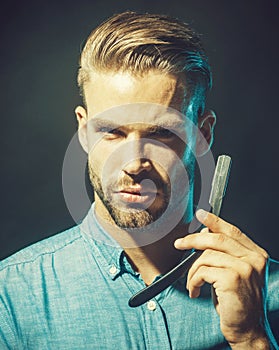 Beauty industry, home skin care concept. Portrait of unshaven man ready to shaving his beard with sharp razor. Handsome