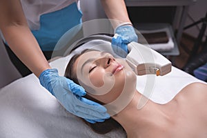 Beauty Injection. Closeup Of Doctor Hands With Syringe Near Female Face. Portrait Of Beautiful Woman Receiving Facial