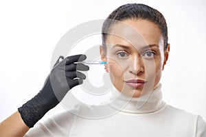 Beauty injection in a face of a young woman. Skin lifting and aesthetic medicine concept. Isolated on a white background