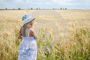 Beauty little girl outdoors enjoying nature wheat field.