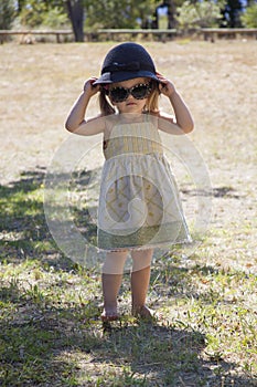 Beauty little girl with sunglasses and a hat