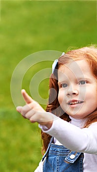 Beauty little woman portrait outdoor. Green background with copyspace