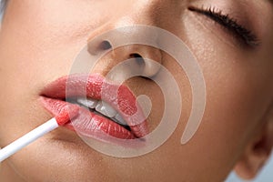 Beauty Makeup. Beautiful Woman Applies Lip Gloss photo