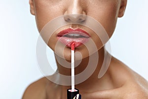 Beauty Makeup. Beautiful Woman Applies Lip Gloss photo