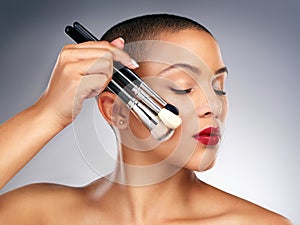 Beauty, makeup brushes and face of woman with red lips in studio for lipstick and skin routine. Cosmetics, confident and