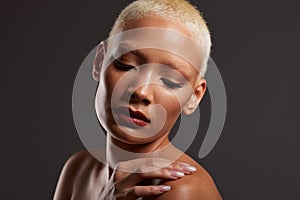 Beauty, makeup and face of black woman with eyes closed in dark studio with platinum hair isolated on grey background