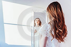 Beauty makeup morning rutine love yourself concept. Young teenage girl looking at reflection in mirror. Young positive