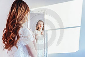 Beauty makeup morning rutine love yourself concept. Young teenage girl looking at reflection in mirror. Young positive woman