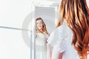 Beauty makeup morning rutine love yourself concept. Young teenage girl looking at reflection in mirror. Young positive woman