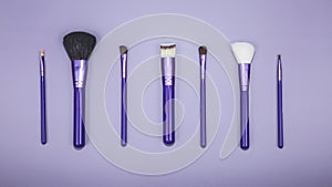 beauty makeup product layout. Fashion woman makeup brushes on violet background. Stylish design background. Creative fashion