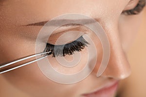 Beauty Makeup. Woman Applying Black False Eyelashes With Tweezer