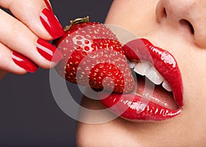 Beauty, makeup and woman with a strawberry in a studio with red nails and lipstick cosmetics. Health, wellness and