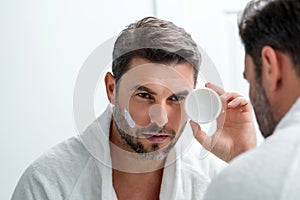 Beauty man applying face cream. Skincare cream, skin anti-aging wrinkle effect. Man applying moisturizer cream on skin