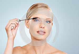 Beauty, mascara and portrait of woman in studio with confidence, makeup for lashes or facial glow. Glamour, cosmetics photo