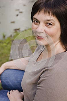 Beauty mature brunette woman in park smiling close up autumn park thinking