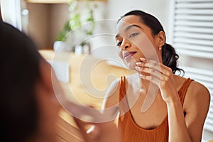 Beauty mexican woman looks in the mirror after getting up