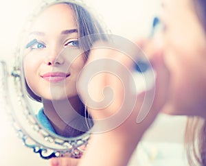 Beauty model girl applying mascara