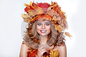 Beauty model girl with autumn bright leaves hairstyle. Beautiful Fashion female with Autumnal Make up and Hair style.