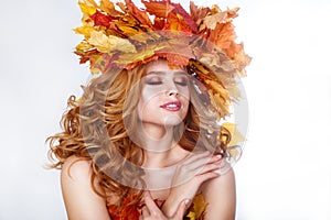 Beauty model girl with autumn bright leaves hairstyle. Beautiful Fashion female with Autumnal Make up and Hair style.
