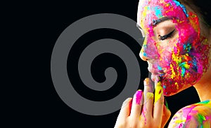 Beauty model girl with colorful paint on her face. Portrait of beautiful woman with flowing liquid paint