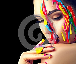 Beauty model girl with colorful paint on her face. Portrait of beautiful woman with flowing liquid paint