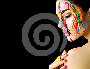 Beauty model girl with colorful paint on her face. Portrait of beautiful woman with flowing liquid paint