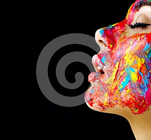 Beauty model girl with colorful paint on her face. Portrait of beautiful woman with flowing liquid paint