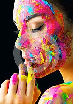 Beauty model girl with colorful paint on her face. Portrait of beautiful woman with flowing liquid paint