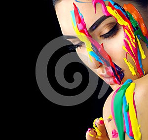 Beauty model girl with colorful paint on her face. Portrait of beautiful woman with flowing liquid paint