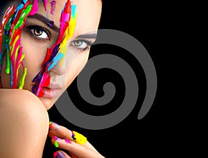 Beauty model girl with colorful paint on her face. Portrait of beautiful woman with flowing liquid paint