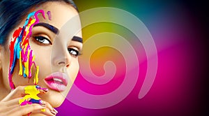 Beauty model girl with colorful paint on her face. Portrait of beautiful woman with flowing paint