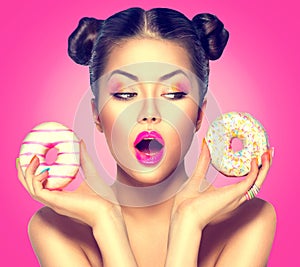 Beauty model girl taking colorful donuts