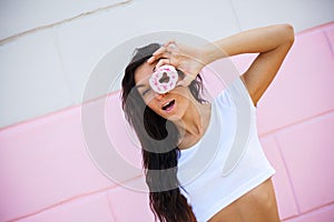 Beauty model girl taking sweets and colorful donuts