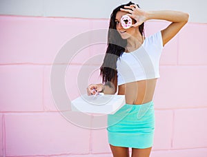 Beauty model girl taking sweets and colorful donuts