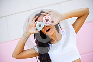 Beauty model girl taking sweets and colorful donuts