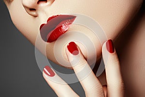 Beauty model. Manicured hand with red nails. Red lips and nails