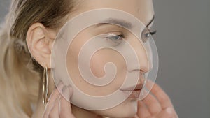 Beauty model touching face skin in slow motion. Close up of young woman face