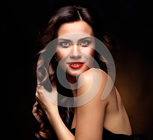 Beauty Model Woman with Long Brown Wavy Hair. Healthy Hair and Beautiful Professional Makeup. Red Lips and Smoky Eyes