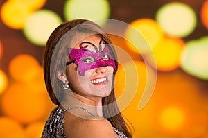 Beauty model woman wearing pink carnival mask in colorful background