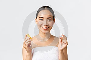 Beauty, personal and intimate care menstrual hygiene concept. Close-up of attractive asian girl in towel showing tampon