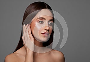 Beauty photo of young brunette woman touching ear
