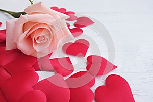 Beauty pink-orange rose and red satin hearts shape on wooden floor. Valentine's day background concept