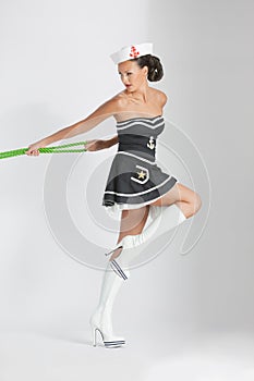 Beauty pinup girl in a sailor suit rope pulling
