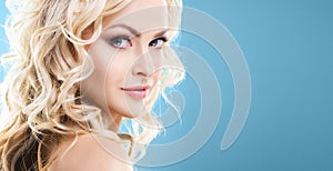 Beauty portrait of attractive blond woman with curly hair and a beautiful hairstyle. Makeup and cosmetics, face lifting