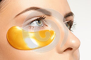 Beauty portrait of an attractive girl with a gold patch under the eye.