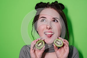 Beauty portrait of attractive young woman with clean radiant skin face with kiwi halves, brunette girl with bare