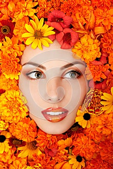 beauty portrait of beautiful female face with orange flowers frame