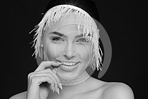 Beauty portrait of a beautiful woman using white lace ribbon. Black background