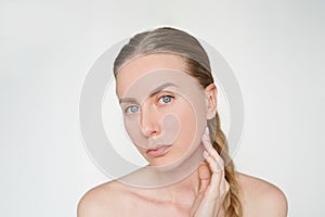 Beauty portrait of beautiful young caucasian woman without makeup touching face with hand. skin care, cosmetology