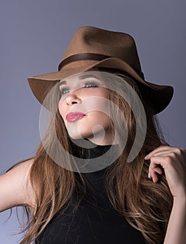 Beauty portrait. Beautiful young lady with a brown hat and black clothes